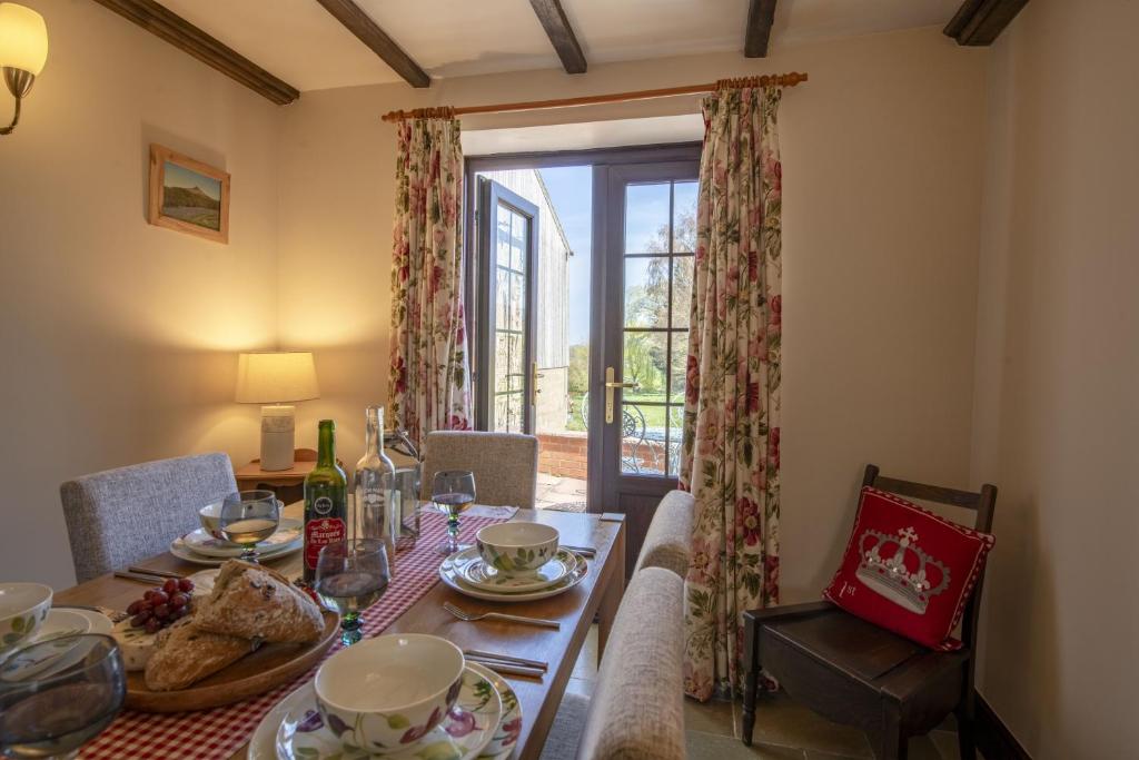 a dining room with a table and a glass door at Lyke Wake Cottage in Northallerton