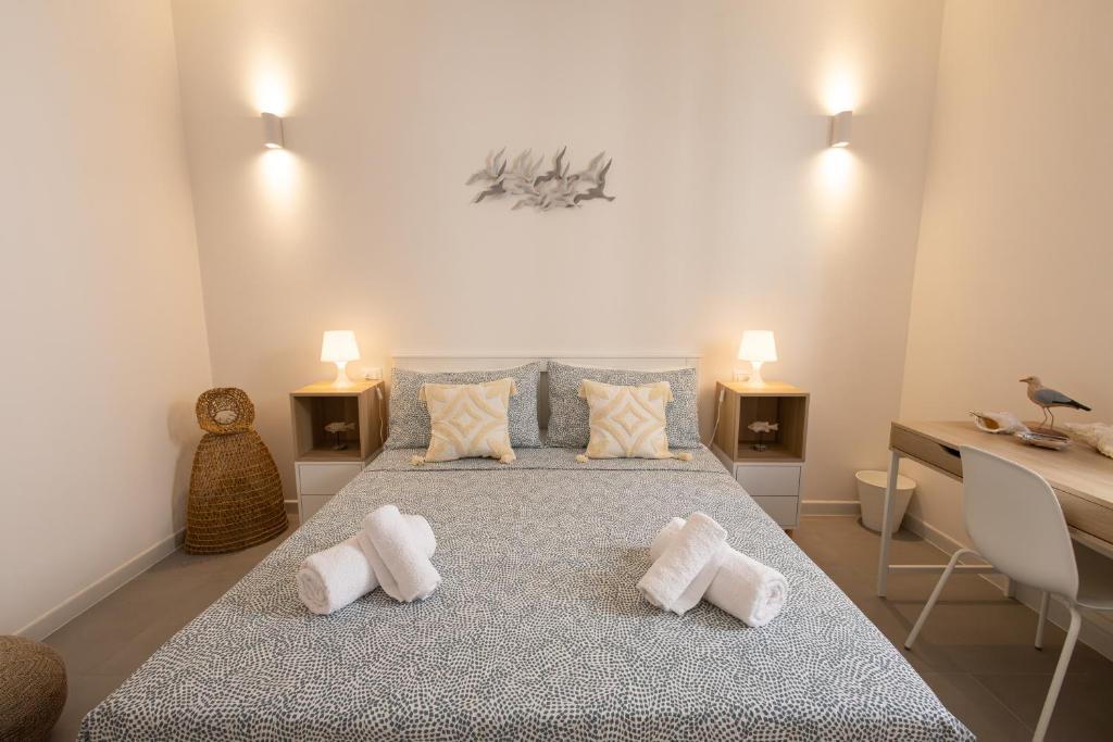 a bedroom with a large bed with towels on it at Montebello Room's in Marettimo