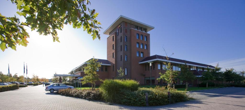 a brick building with a car parked in front of it at Hotel van der Valk Wolvega-Heerenveen in Wolvega