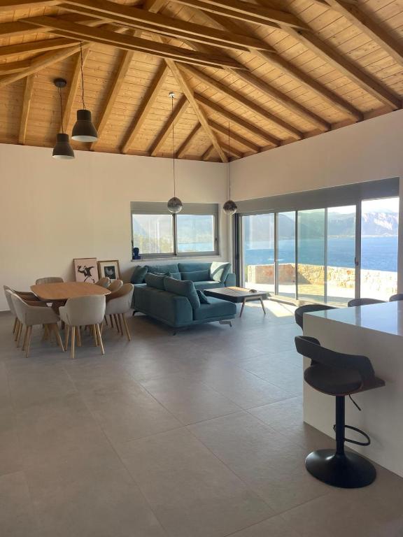 a living room with a couch and a table and chairs at Contemporary villa with pool and sea view in Poulithra