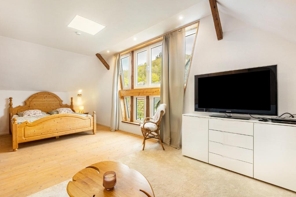 a living room with a flat screen tv and a bed at Ferienwohnung in Anni's Ferienhaus in Großaltenstädten