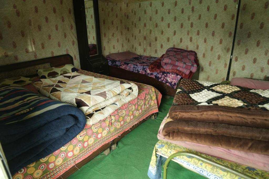 a room with three beds in a room at Lord Shiva Camps in Sari