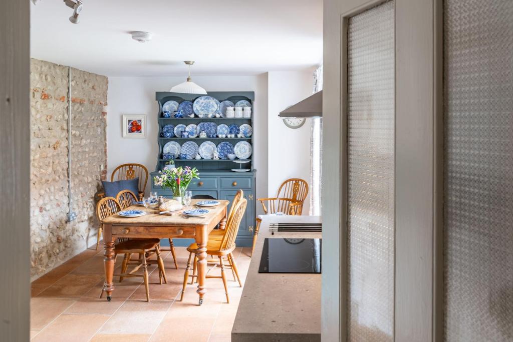 a kitchen and dining room with a wooden table and chairs at Mollies Cottage in Overstrand