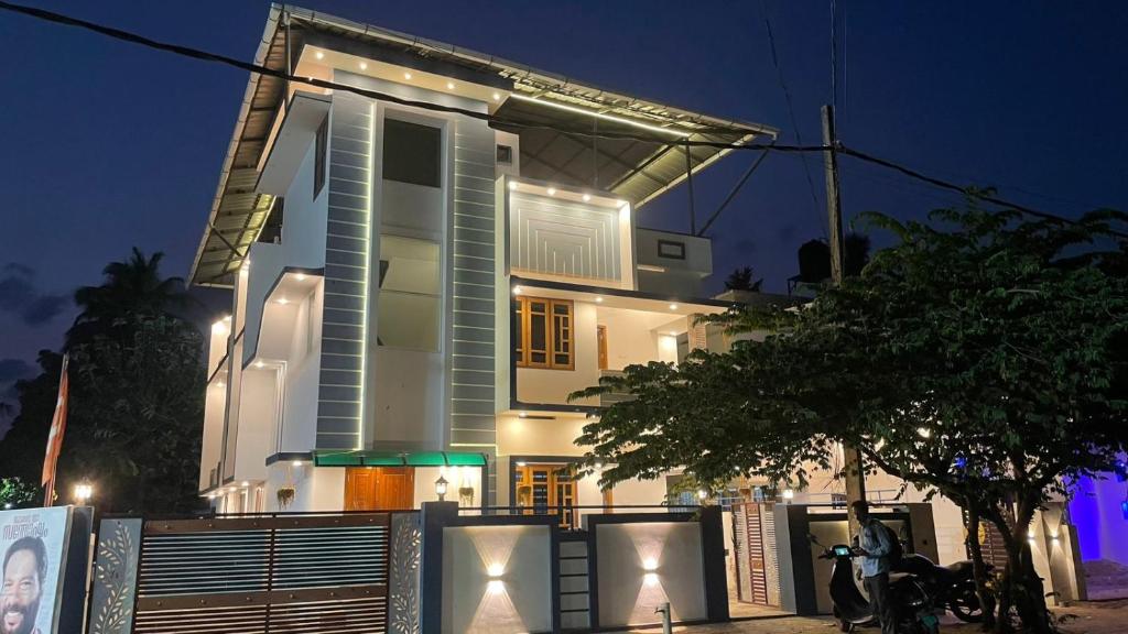 a white building with a fence in front of it at Souparnika apartments in Varkala