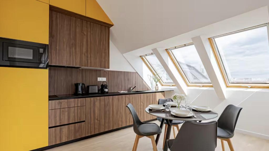 a kitchen and dining room with a table and chairs at A60 Apartment Hotel in Budapest