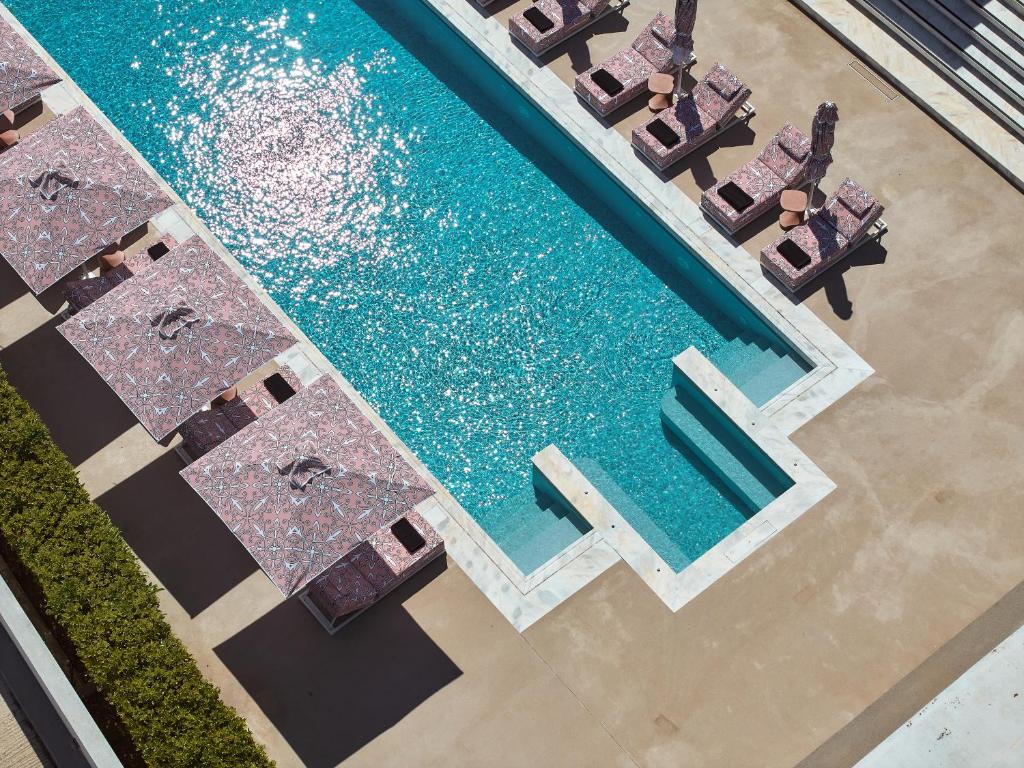 an overhead view of a swimming pool with chaise lounges at Tzanis Resort Skyros in Skiros
