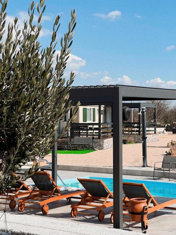 a group of chairs sitting next to a swimming pool at Auto-kamp Dvije suze 1 in Brištane