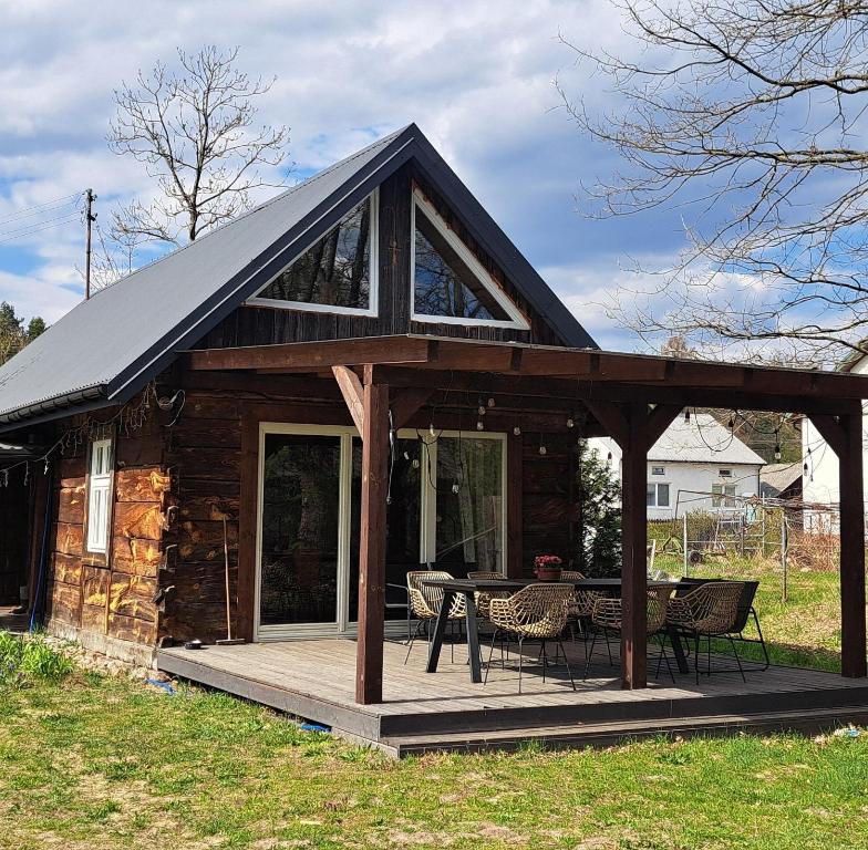 a cabin with a wooden deck and a table at Józefowa Chata in Rudnik