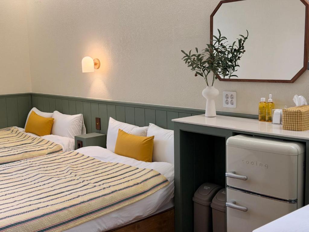a hotel room with two beds and a mirror at Casa olive 까사올리브 in Millak-tong
