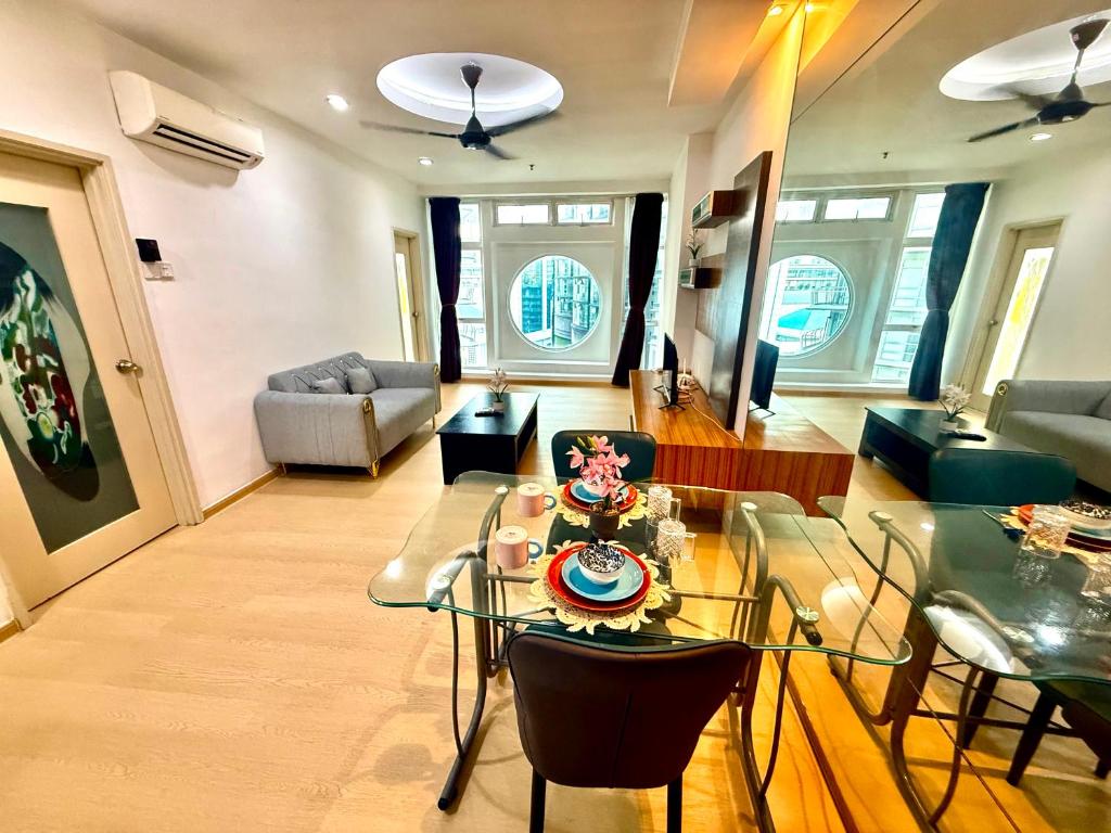 a living room with a glass table and chairs at Parkview Suites Near By Klcc in Kuala Lumpur
