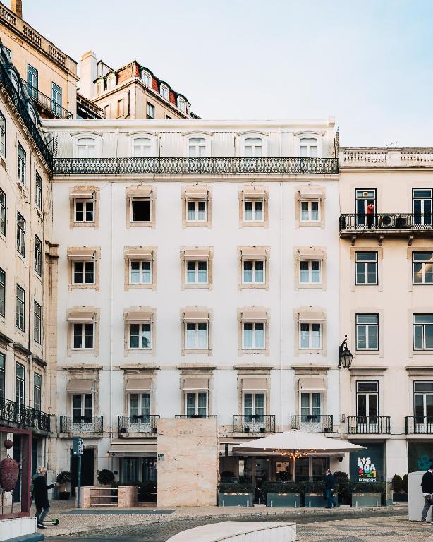 a large white building with people walking in front of it at AlmaLusa Baixa/Chiado in Lisbon