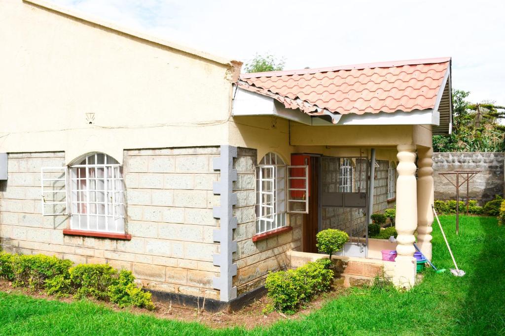 a small white brick house with a red roof at Eldoville Home in Eldoret