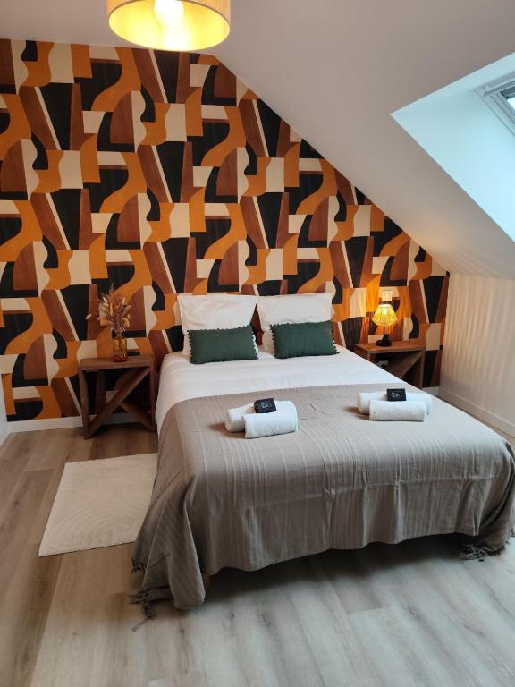 a bedroom with a large bed with a geometric wall at l'imprimerie in Malestroit