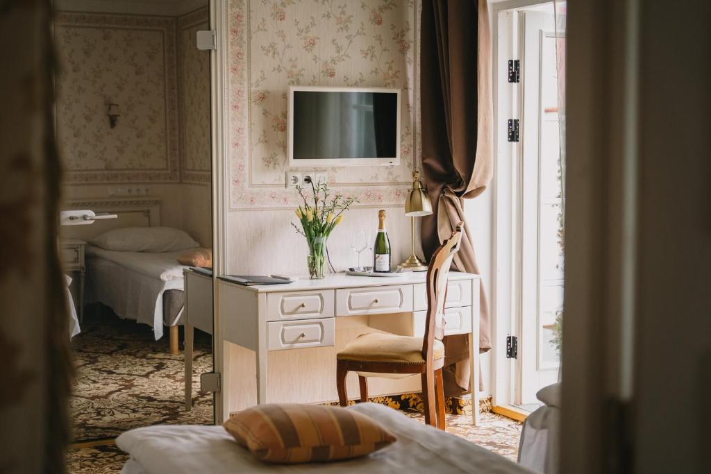 a bedroom with a desk with a television and a bed at Ööbikuoru Villa in Rõuge