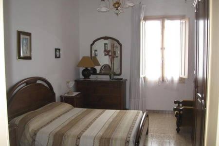 a bedroom with a bed and a mirror and a window at Appartamento Vacanze in Stintino