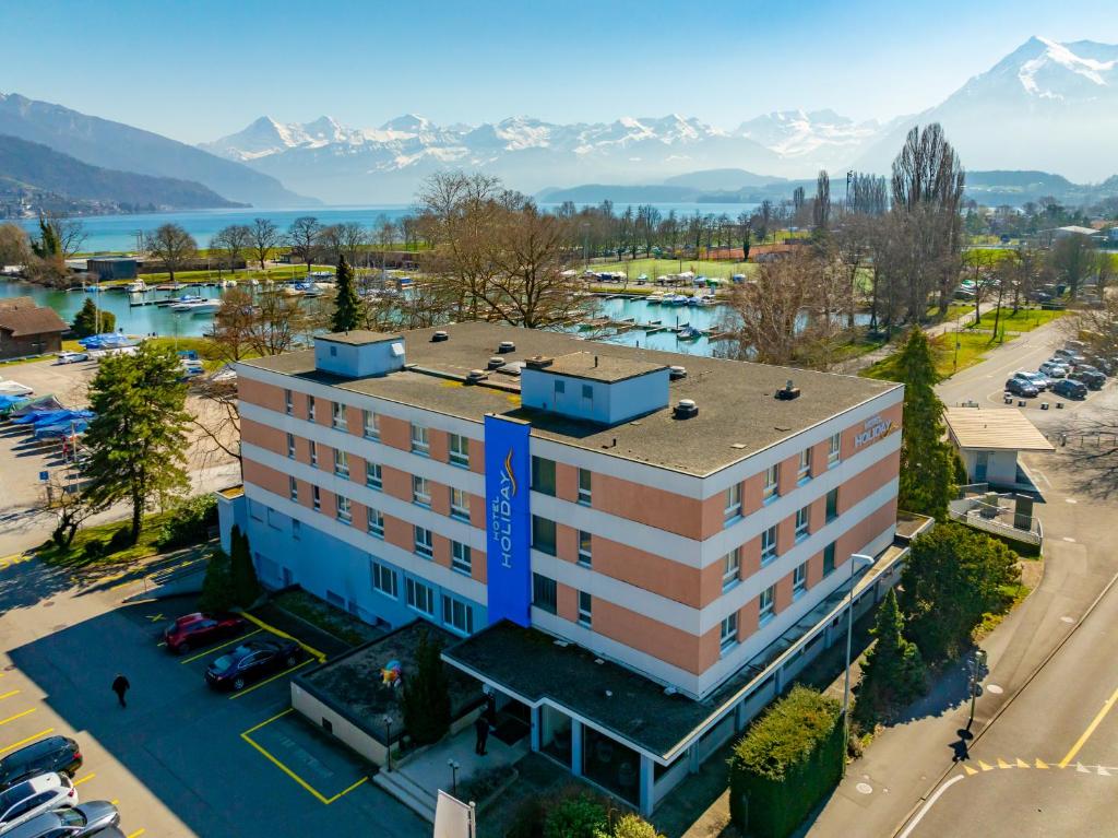 an overhead view of a building with mountains in the background at Hotel Holiday Thun in Thun