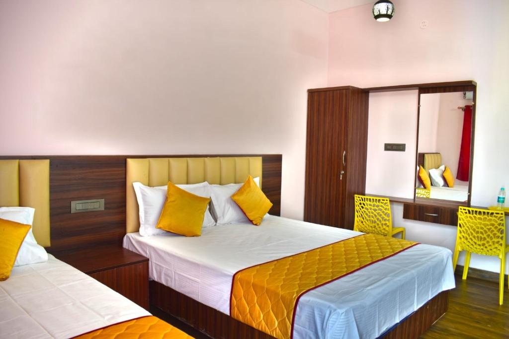a hotel room with two beds and a mirror at Bio Villas Resorts in Yelagiri