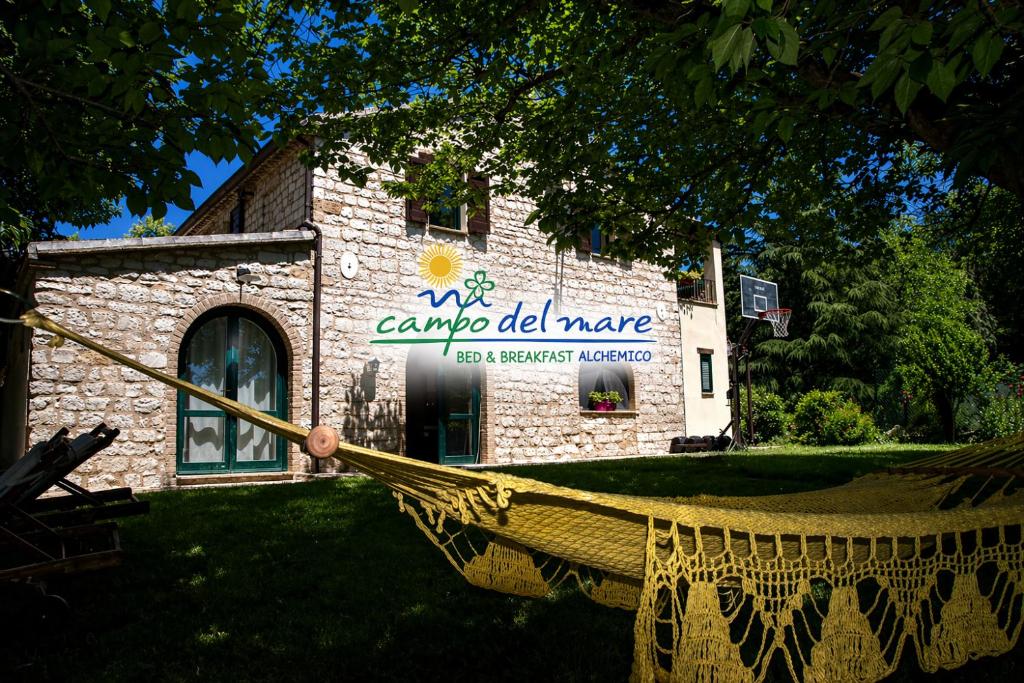 a hammock in front of a stone building at B&B Campo del Mare in Sirolo