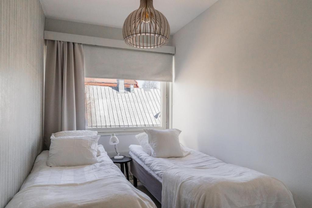 two beds in a room with a window at Nordic Nook By Elys Collection in Rovaniemi