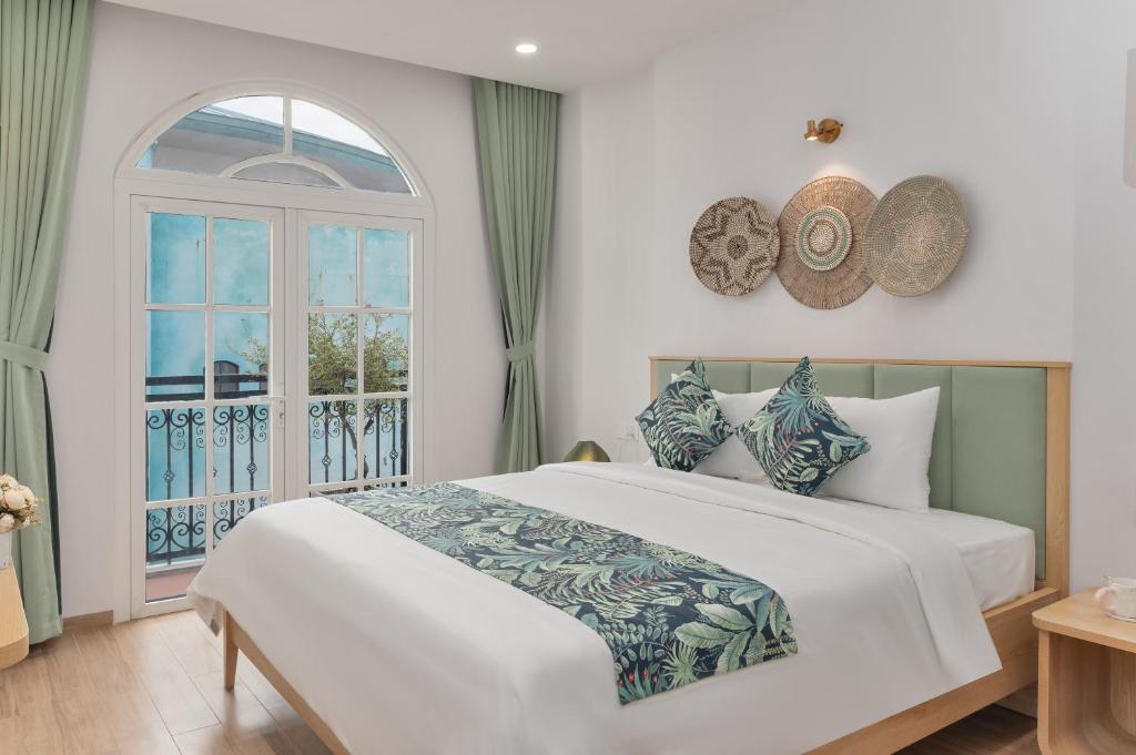 a bedroom with a large bed and a window at Casa Del Mar Hotel & Apartment - Sunset Town, Phu Quoc in Phú Quốc