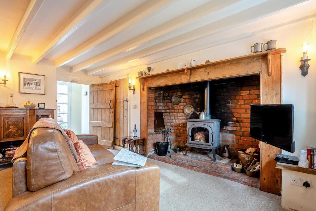 a living room with a couch and a fireplace at 1 Bed in Evesham oc-55177 in Bretforton