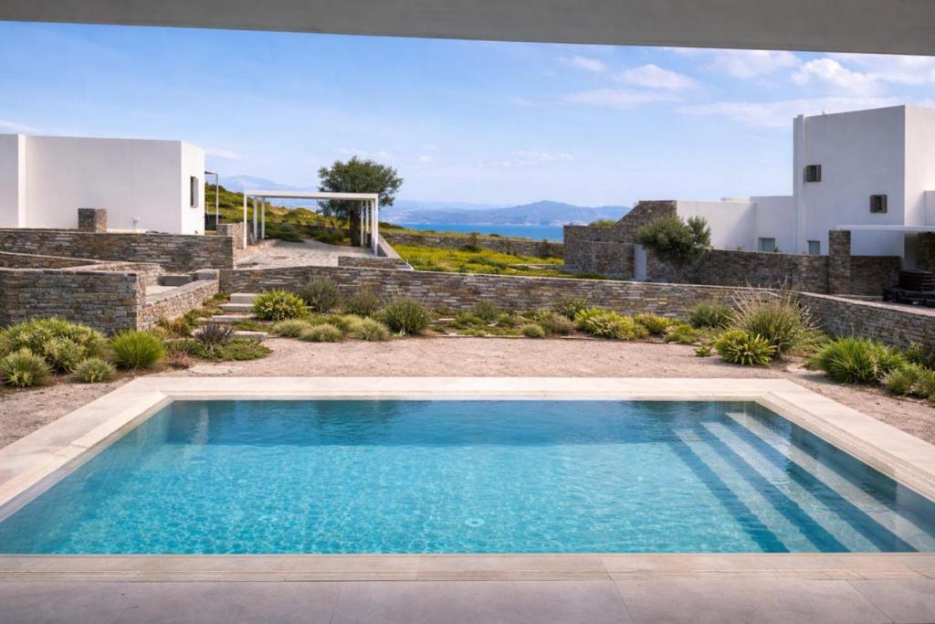 a swimming pool in front of a house at Alkinoe Villa Paros in Isterni