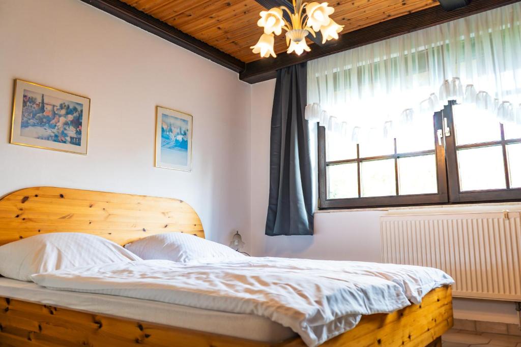 a bedroom with a wooden bed and a window at Hotel Garni Zielinski in Sindelfingen