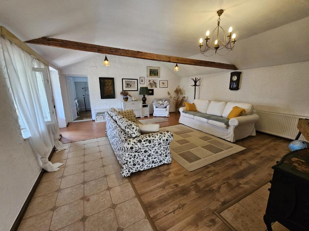 a living room with two couches and a chandelier at Guest House Luca in Galda de Jos