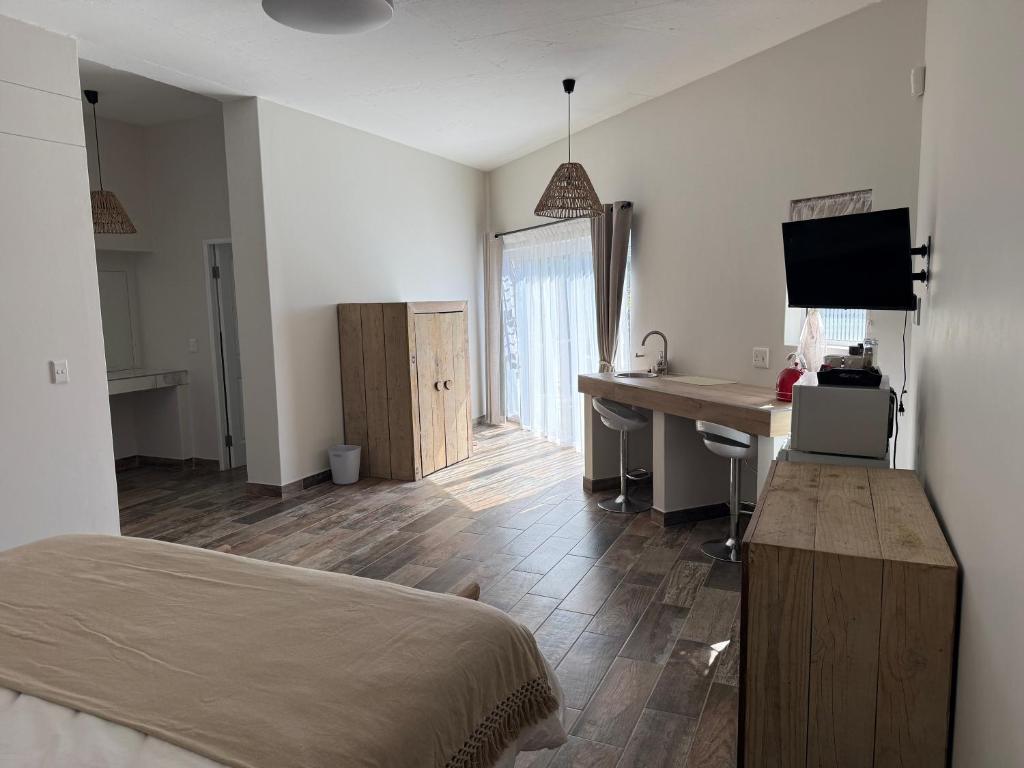 a bedroom with a bed and a desk with a computer at Berg & Baai guesthouse in Plettenberg Bay