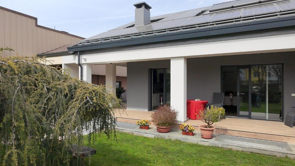 a house with potted plants on the porch at House Martina in Limana