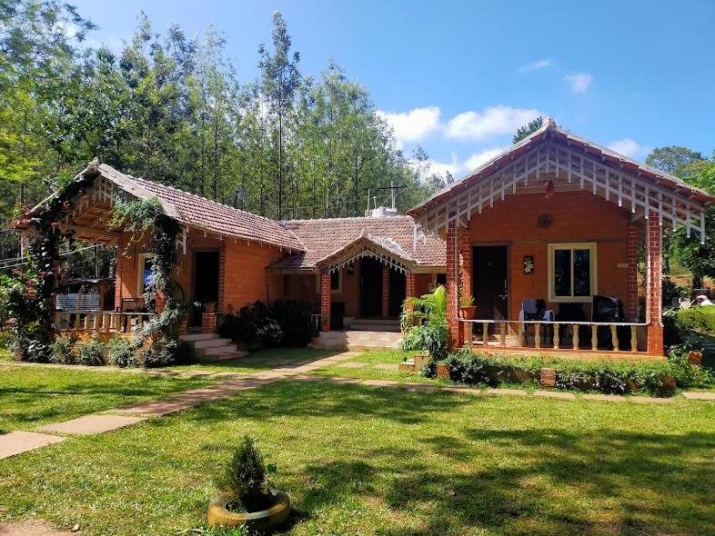 a house with a grass yard in front of it at Lovelynest homestay in Attigundi