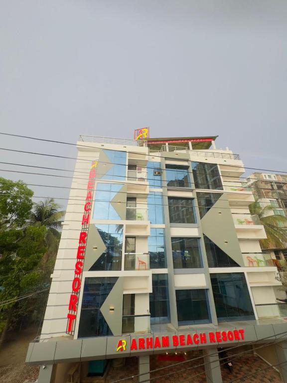 an apartment building with a red sign on it at Arham Beach Resort in Cox's Bazar