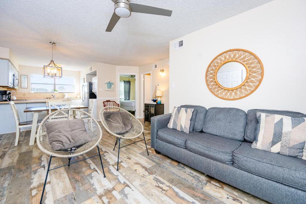 a living room with a blue couch and a kitchen at Lei Lani 108 condo in Orange Beach
