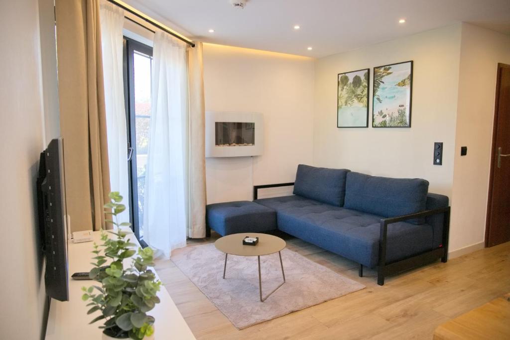 a living room with a blue couch and a table at Haus Titania App 4 inkl WLAN in Grömitz