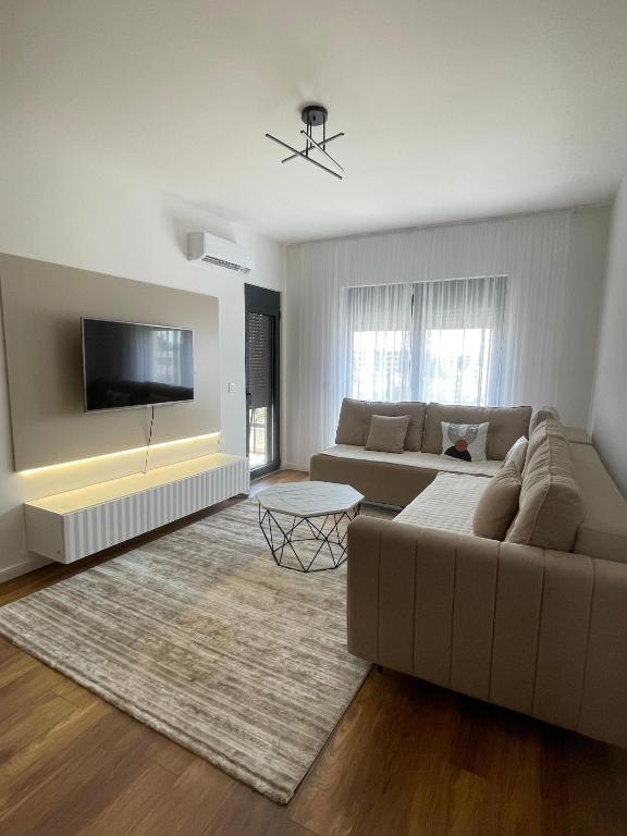 a living room with a couch and a flat screen tv at Bliss by the Sea in Ulcinj