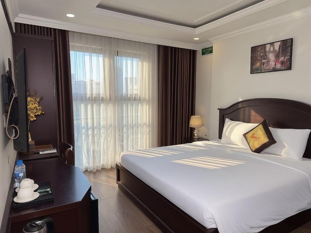 a bedroom with a large bed and a window at Mercy Hotel in Hanoi