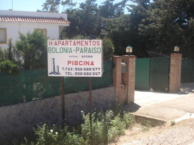 a sign in front of a fence with a building at Apartamentos Bolonia Paraiso in Bolonia