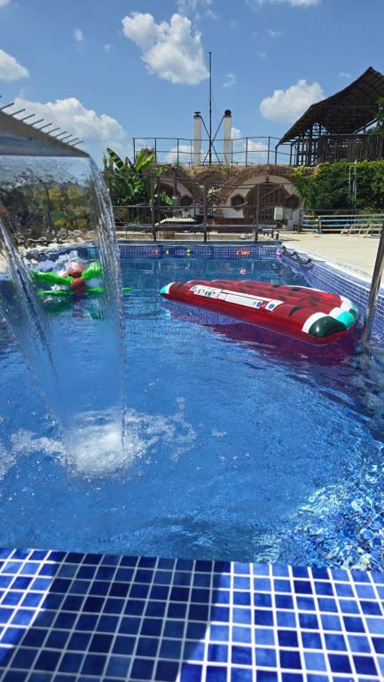 a pool with a water fountain and a boat in it at La Hotar in Buchin