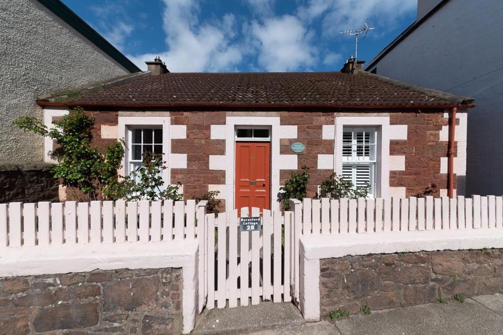 a white picket fence in front of a small house at Beresford Cottage in North Berwick