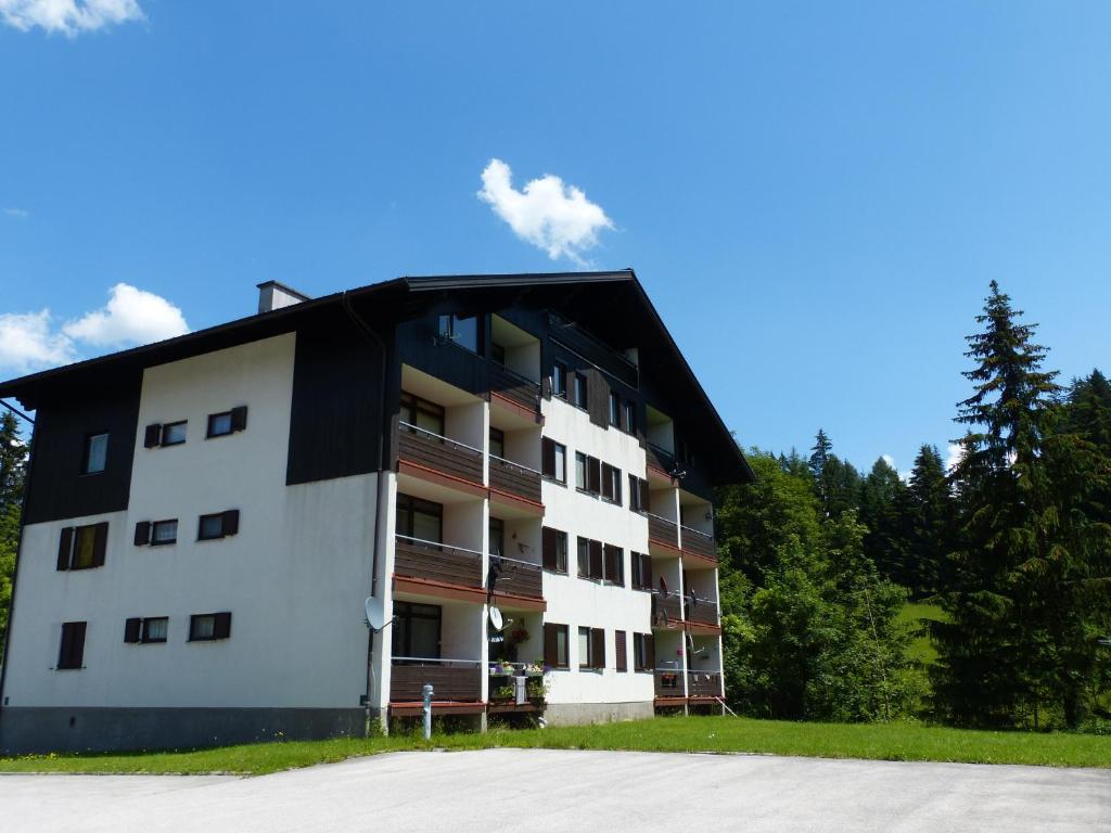 a white apartment building with a black roof at Apartmán Grimming in Tauplitz