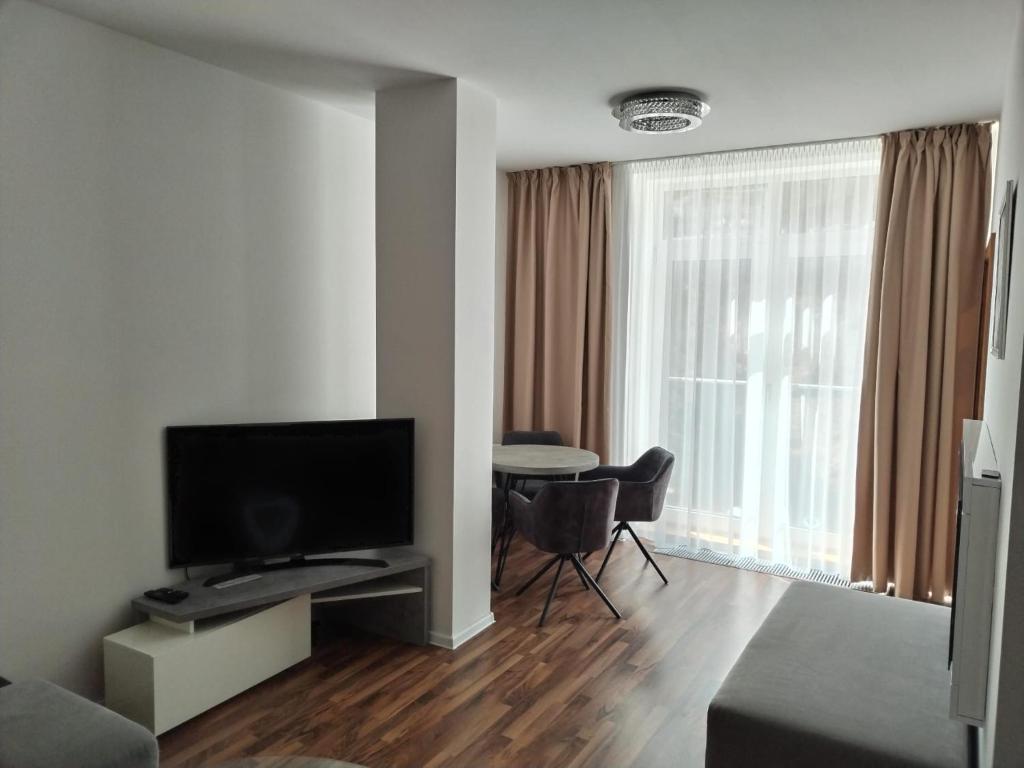 a living room with a flat screen tv and a table at Oliver apartmán 6 in Štrbské Pleso
