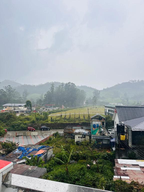 a view of a town with a hill in the background at MSP Amma Cottage in Munnar