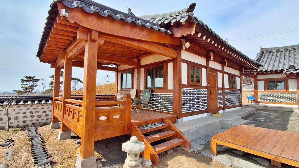 a small wooden house with a bench and a table at 홍성군 편백나무 남당한옥 in Hongseong
