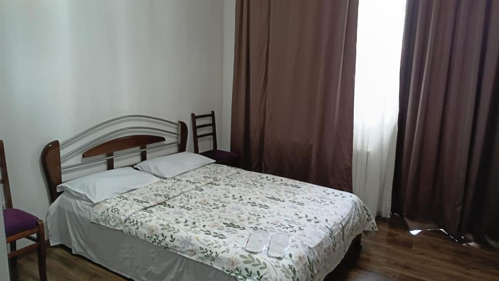 a bedroom with a bed with a comforter on it at Saburtalo VIP in Tbilisi City