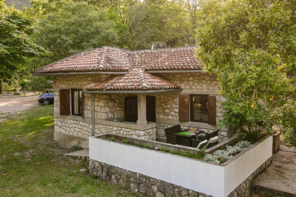 a small stone house with a tree at Campsite & Holiday Resort Medveja -by Liburnia Hotels & Villas in Medveja