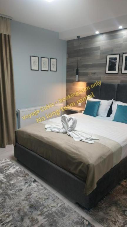 a bedroom with a large bed with blue pillows at VOYAGE CUBIC Adults Only in Sibiu