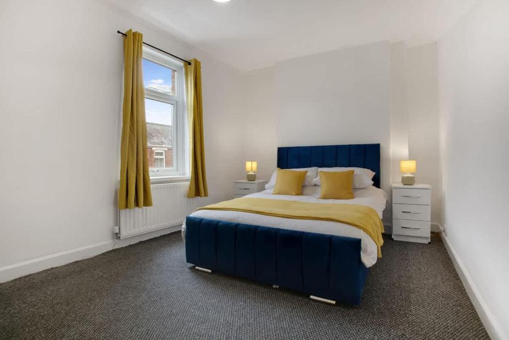 a bedroom with a blue bed with yellow pillows at Freshly Renovated, Feels Like Home, Sleeps 3 in Chester-le-Street