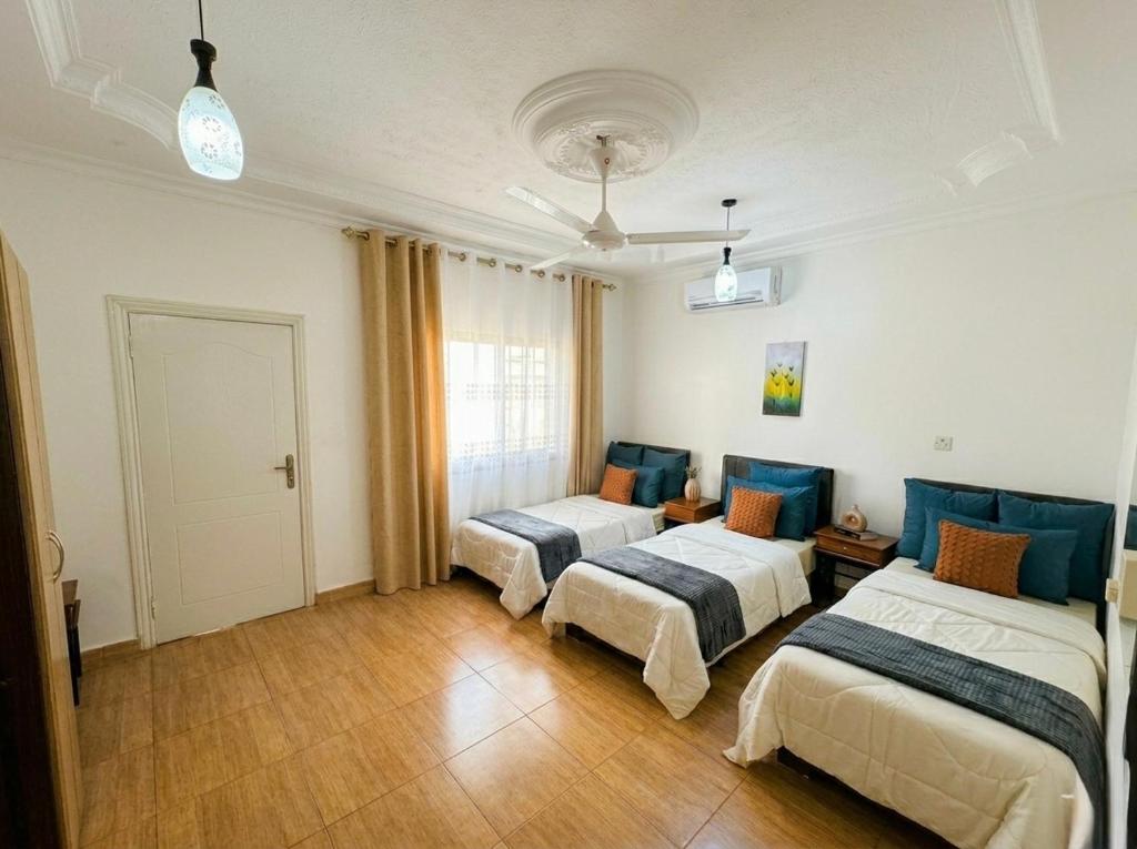 a room with three beds in a room at CozyQ Apt in Aqaba