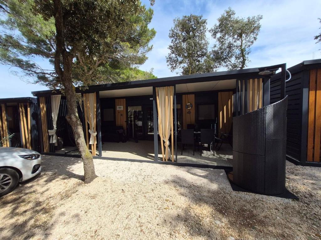 a house with a black exterior with a tree at SUNNY Rest Nest in Pakoštane
