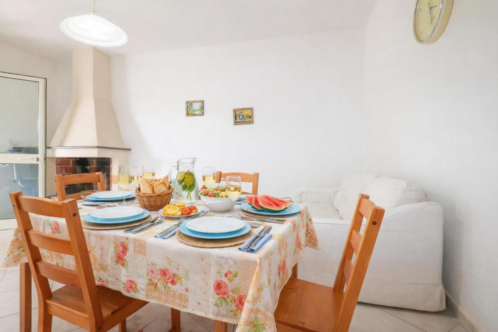 a dining room with a table and a couch at Rosa Fronte Mare in Torre Mozza